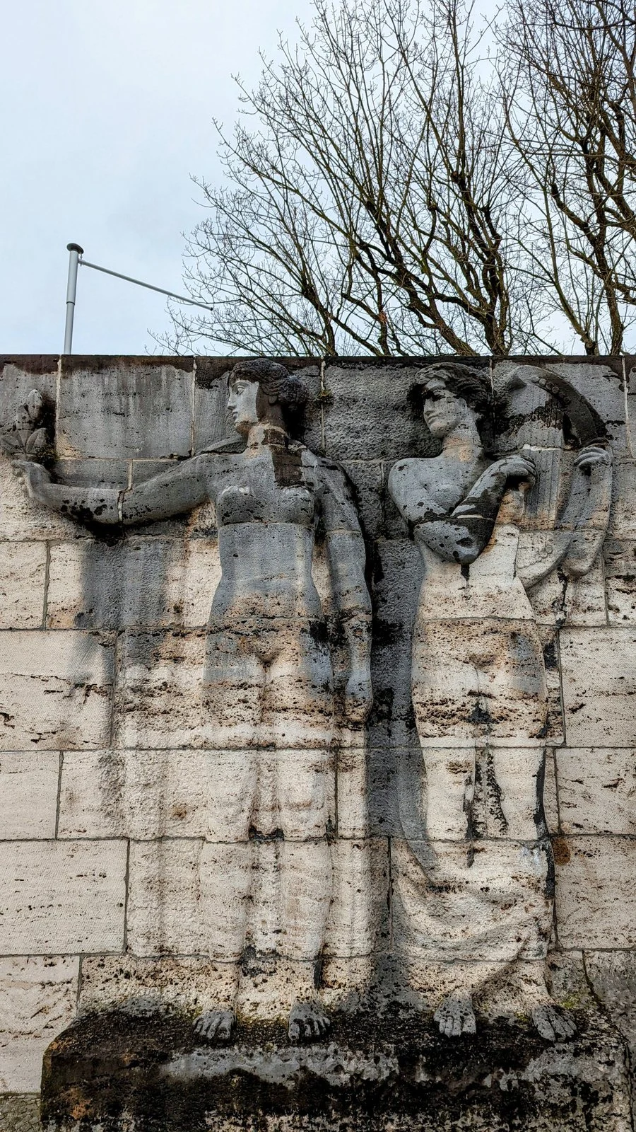 Hochrelief mit zwei Frauenfiguren an der Travertinwand am Eingang der Waldbühne im Olympiagelände