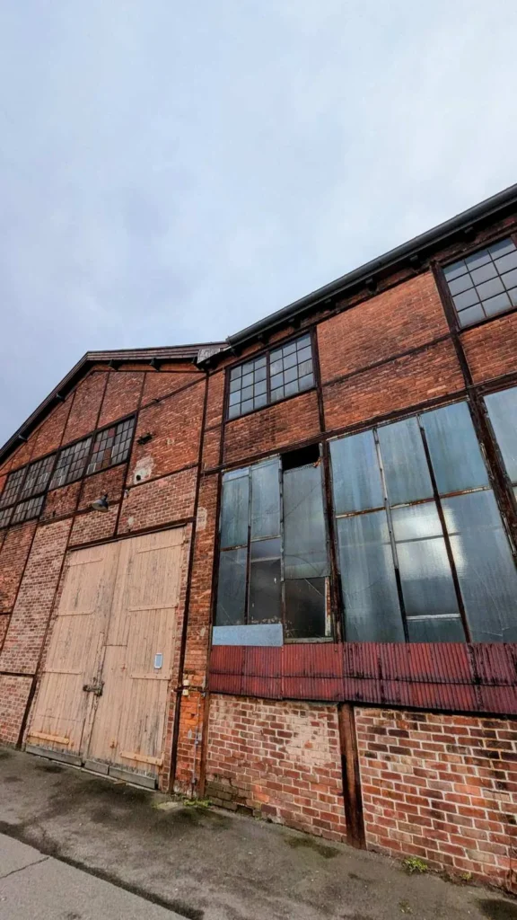 Alte Backsteinhalle mit Falttor und großen Fenstern auf dem Industriegelände Bergmann-Borsig in Wilhelmsruh