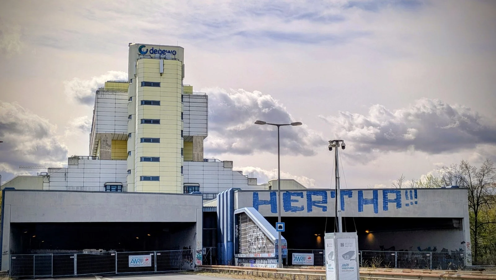 Aufgemalter Schriftzug HERTHA!!! an einer Betonwand in Wilmersdorf, dahinter ein Hochhaus