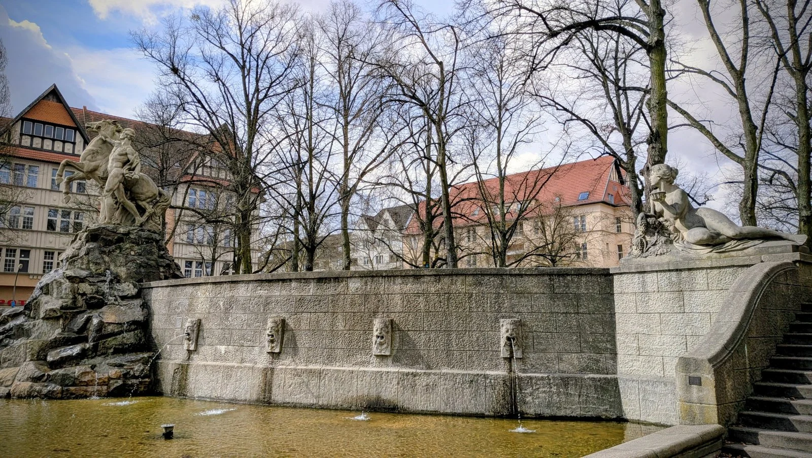 Siegfriedbrunnen am Rüdesheimer Platz in Wilmersdorf mit Pferdegruppe, Löwenköpfen und liegender Flussfigur