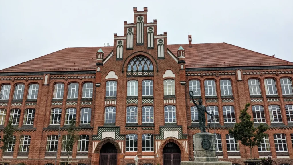 Rotes Backsteingebäude mit Stufengiebel und Rundbogentüren in Wittenberge
