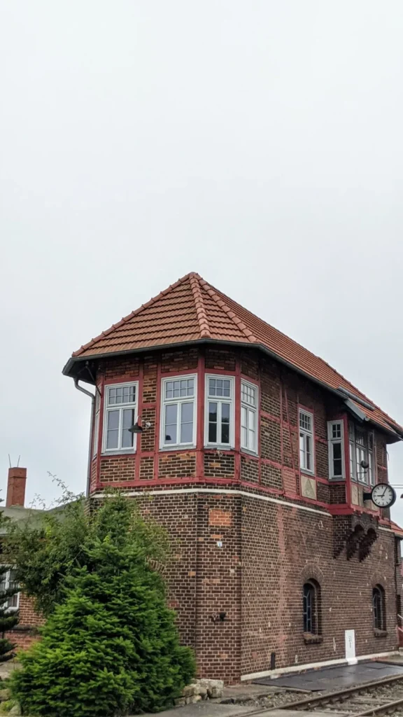 Backsteinstellwerk mit verglastem Holzerker und Uhr in Wittenberge