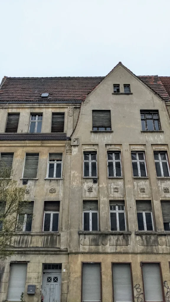 Verfallener Gründerzeitbau mit Giebel und geschlossenen Fensterläden in Wittenberge