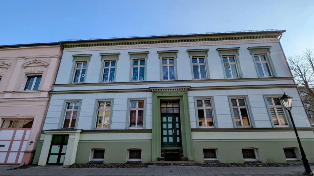 Zweigeschossiges Bürgerhaus mit hellgrüner Fassade, weißen Fenstergewänden und grüner Haustür in der Friedrichstraße in Wriezen