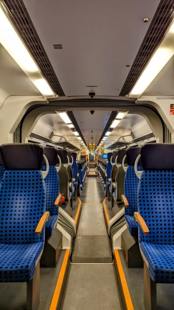Fast leerer Innenraum eines Regionalzugs mit blauen Sitzen auf der Fahrt nach Wünsdorf-Waldstadt