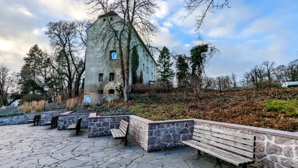 Schloss Zossen hinter einer Terrasse mit Bänken
