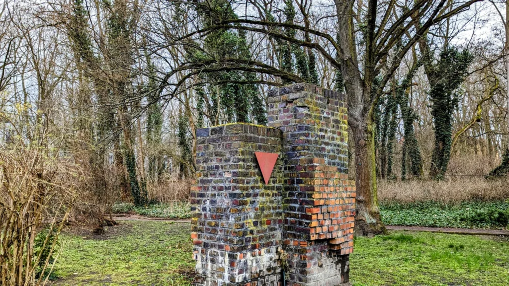 Klinkerpfeiler mit rotem Winkel am Eingang des Ehrenhains für die Verfolgten des Naziregimes auf dem Zentralfriedhof Friedrichsfelde